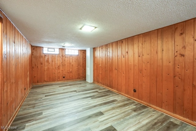 below grade area featuring wooden walls and light wood-style floors