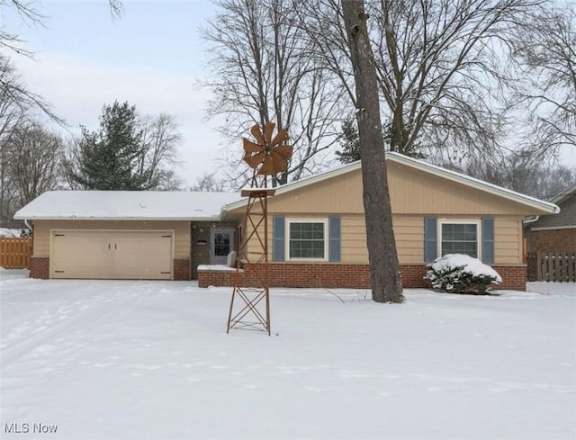 single story home with a garage, fence, and brick siding