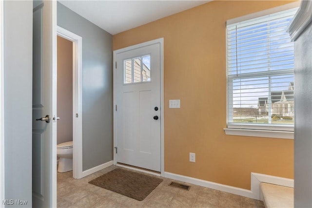 foyer entrance with visible vents, plenty of natural light, and baseboards