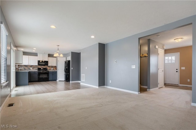 unfurnished living room with light colored carpet, visible vents, baseboards, and recessed lighting