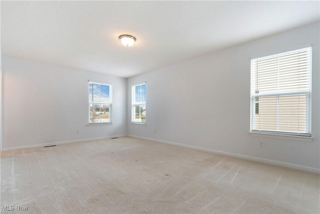 empty room with baseboards and light colored carpet