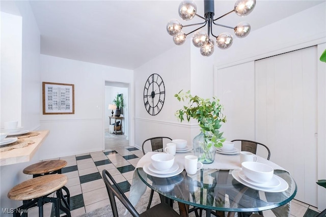 dining space featuring light tile patterned floors and an inviting chandelier