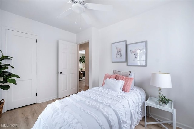 bedroom featuring light wood-style floors, ceiling fan, and baseboards