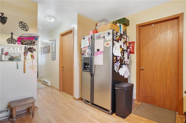 kitchen featuring a baseboard heating unit, light wood finished floors, and stainless steel fridge