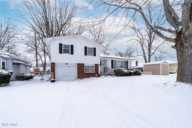 tri-level home with brick siding, an attached garage, and a storage shed