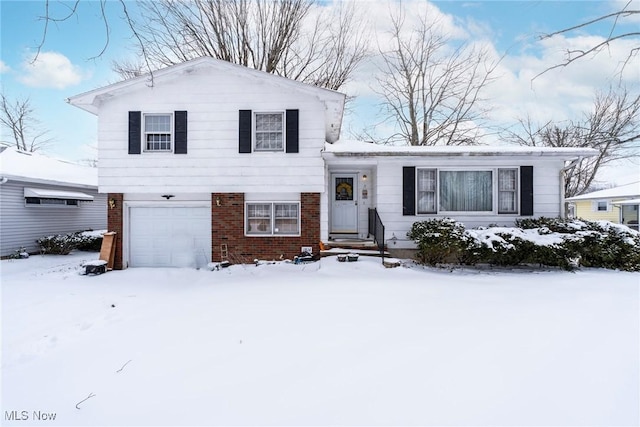 split level home featuring brick siding and an attached garage