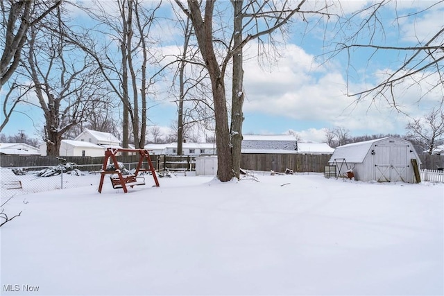 snowy yard with fence and a playground