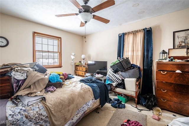 carpeted bedroom featuring a textured ceiling and a ceiling fan