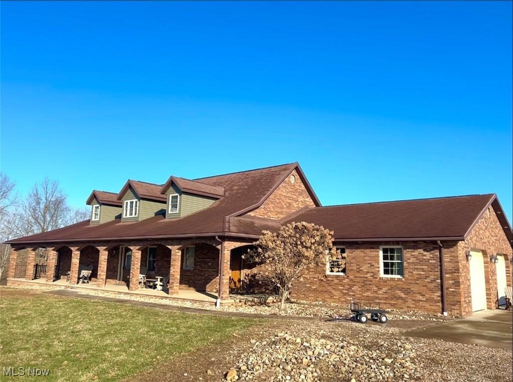 view of property exterior with a yard, brick siding, and an attached garage