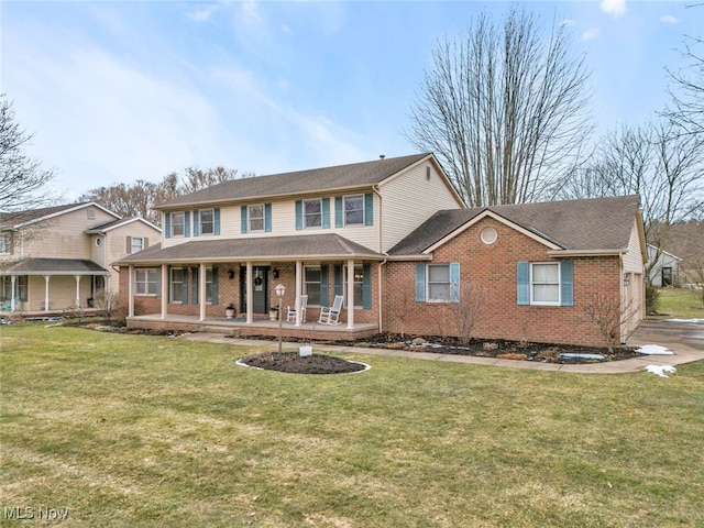 view of front of house with covered porch, a front lawn, and brick siding