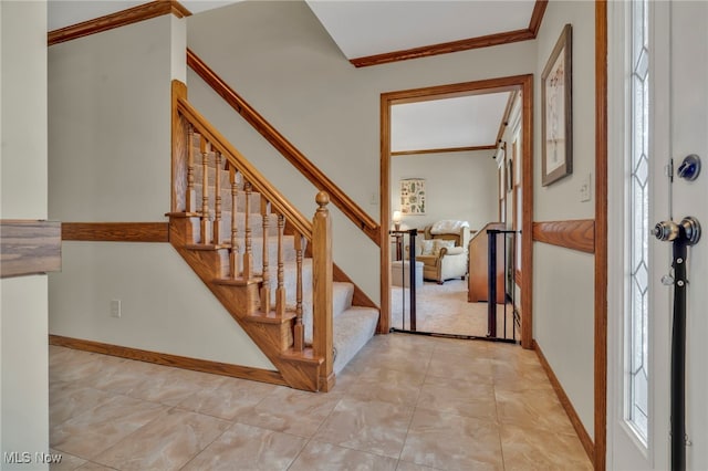 entryway featuring ornamental molding, stairway, and baseboards