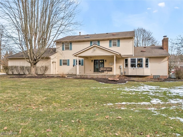 back of house with a patio area, an outdoor fire pit, a chimney, and a lawn