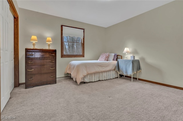 bedroom with light carpet and baseboards