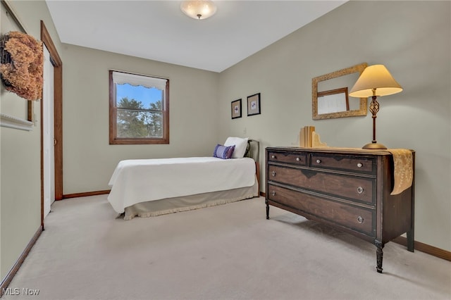 bedroom featuring baseboards and light colored carpet