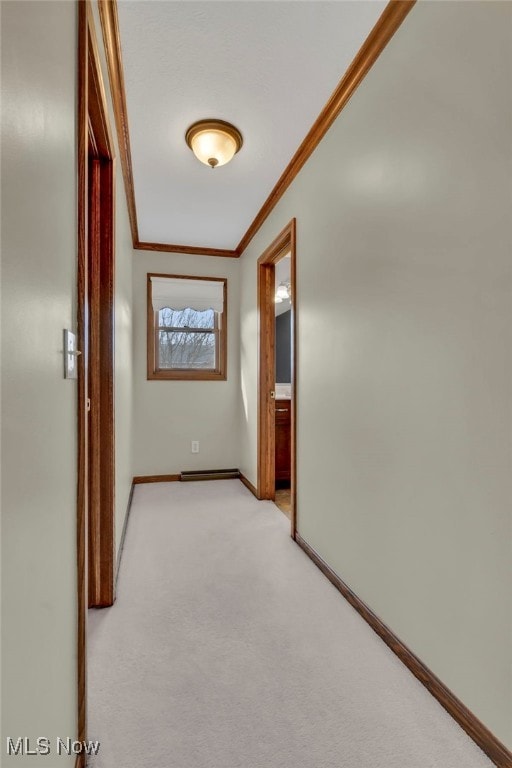 corridor with baseboards, light colored carpet, and crown molding