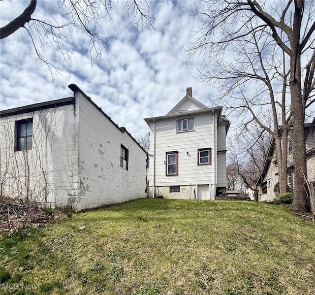 rear view of property with a yard and a chimney