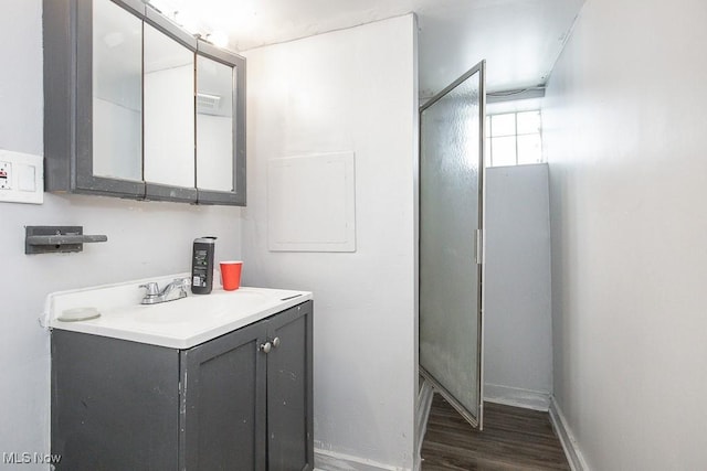 bathroom featuring baseboards, wood finished floors, and vanity