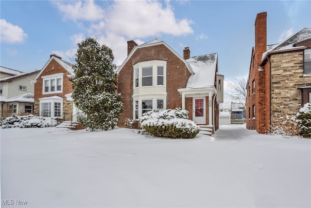 view of front of house featuring brick siding and a chimney