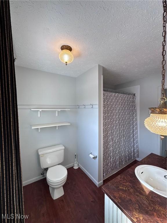 bathroom featuring wood finished floors, toilet, and baseboards