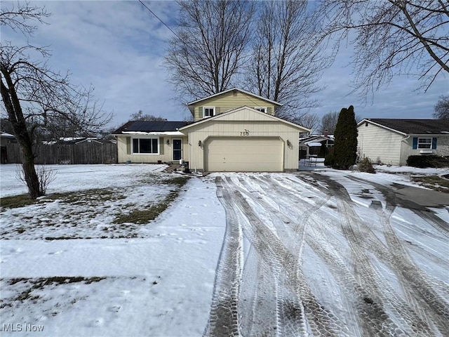 view of front of house with a garage and fence