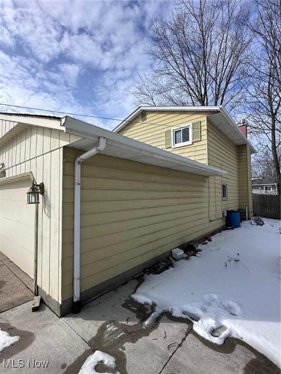 view of snowy exterior featuring a garage