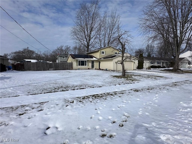 exterior space featuring an attached garage, fence, and a residential view