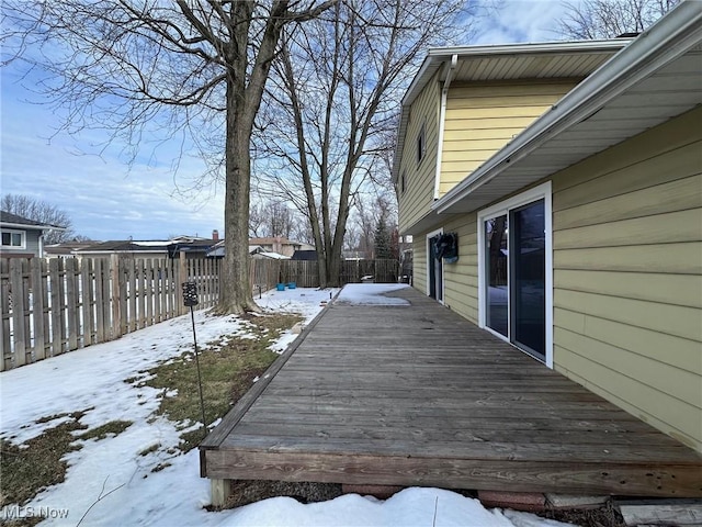 snow covered deck featuring a fenced backyard