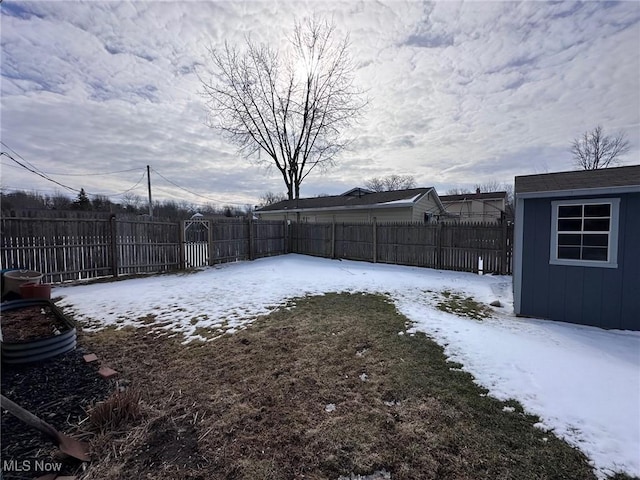 yard covered in snow featuring an outdoor structure and a fenced backyard