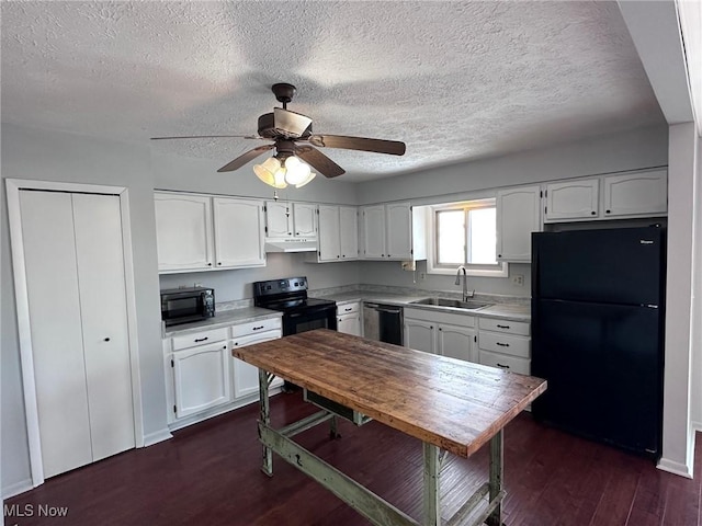 kitchen with light countertops, white cabinetry, a sink, under cabinet range hood, and black appliances