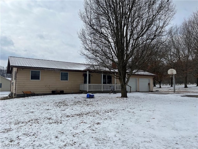 view of front of house featuring a garage, a porch, and metal roof