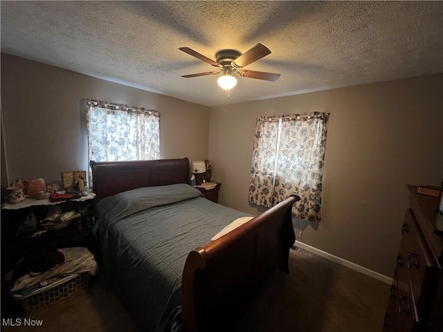 bedroom with dark colored carpet, ceiling fan, a textured ceiling, and baseboards