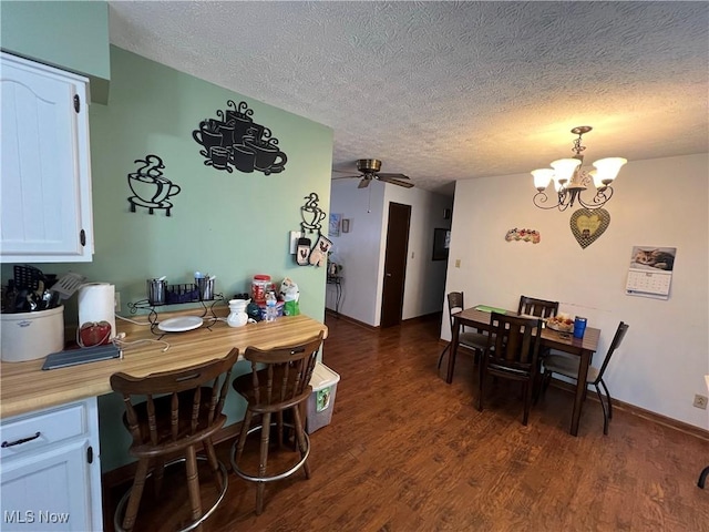 dining space with baseboards, dark wood finished floors, a textured ceiling, and ceiling fan with notable chandelier