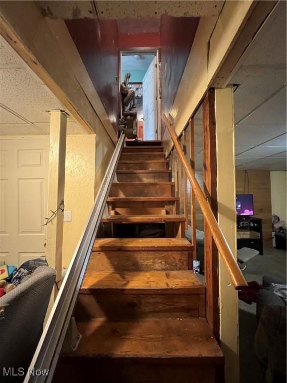 stairs featuring a drop ceiling