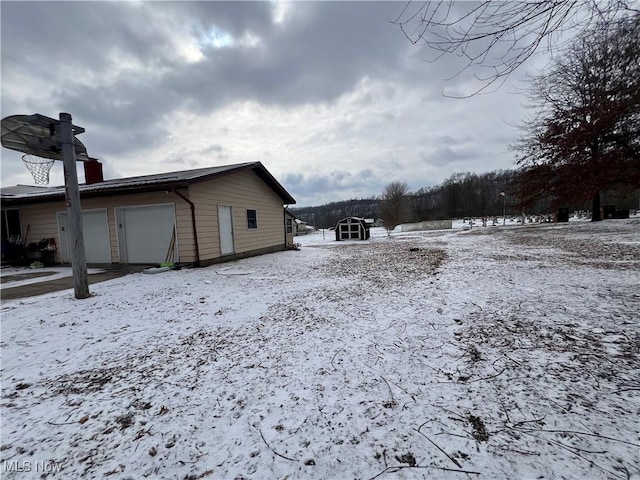 view of snowy exterior featuring a garage