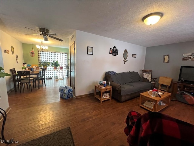 living room featuring ceiling fan, dark wood finished floors, and a textured ceiling