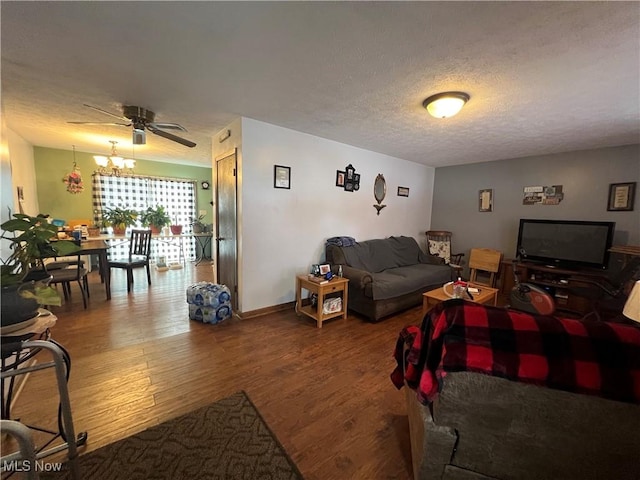 living area with a textured ceiling, ceiling fan with notable chandelier, and wood finished floors