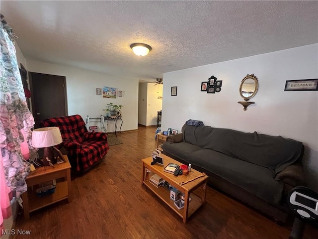 living area with a textured ceiling and dark wood-type flooring