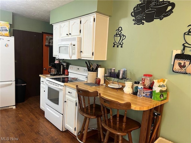 kitchen with white appliances, white cabinets, dark wood-style flooring, light countertops, and a textured ceiling