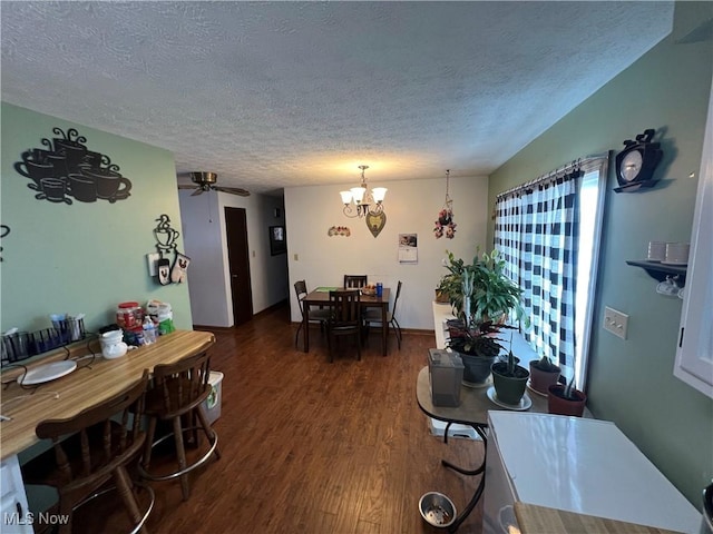 dining space featuring a textured ceiling, dark wood-type flooring, and ceiling fan with notable chandelier