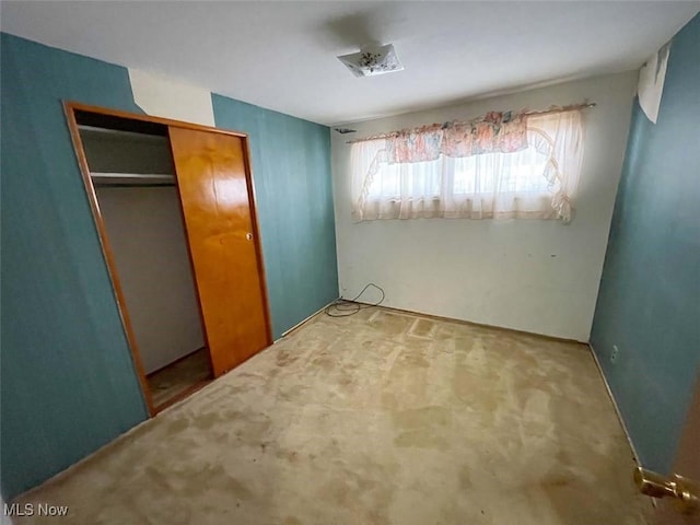 unfurnished bedroom featuring carpet floors and a closet