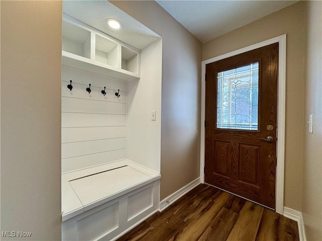 mudroom with dark wood-style floors and baseboards