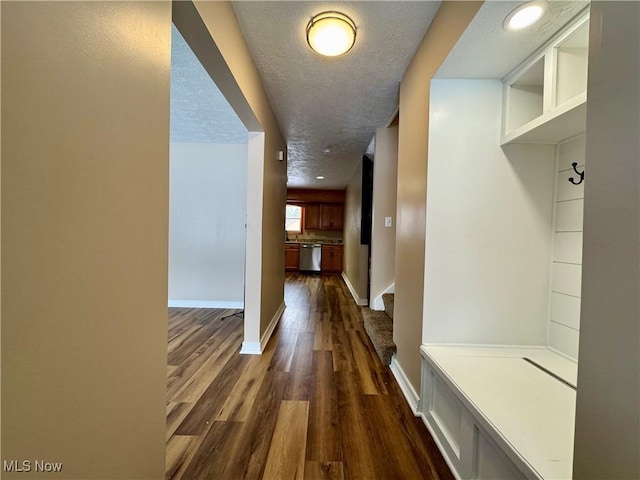 corridor featuring baseboards, dark wood-style flooring, a textured ceiling, and recessed lighting