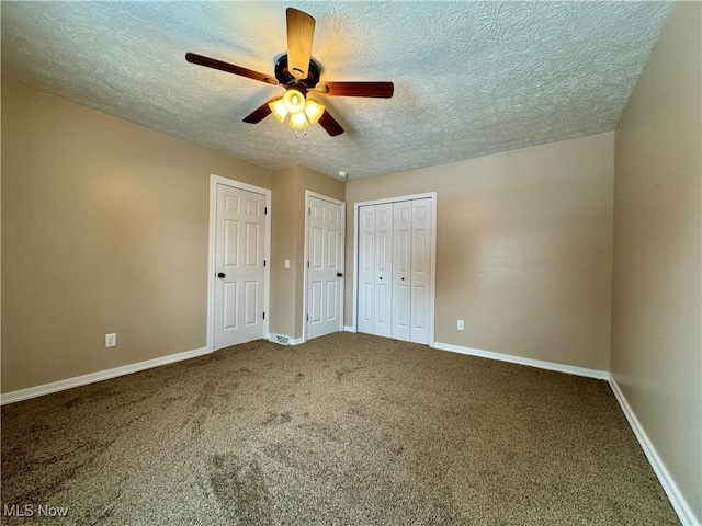 unfurnished bedroom featuring a textured ceiling, carpet floors, ceiling fan, and baseboards