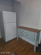 interior space featuring white cabinetry, dark wood-style flooring, and freestanding refrigerator