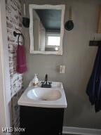 bathroom featuring vanity and brick wall