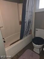 full bath with toilet and shower / bathtub combination with curtain