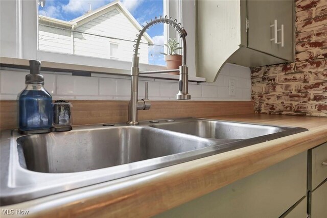1304 Foster Ave, Cambridge, OH 43725 - room details with a hot tub, backsplash, a sink, and light countertops