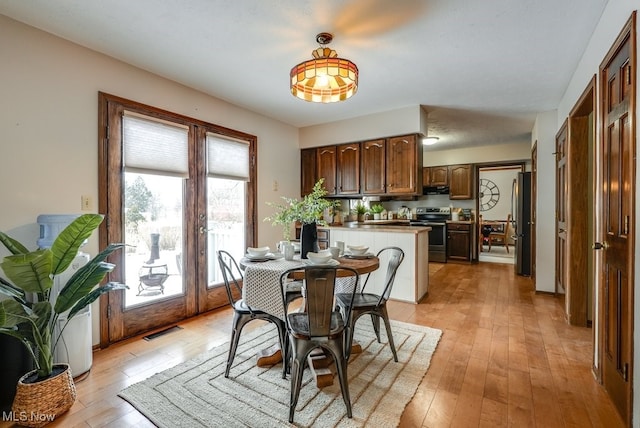 dining room with french doors, visible vents, and light wood finished floors