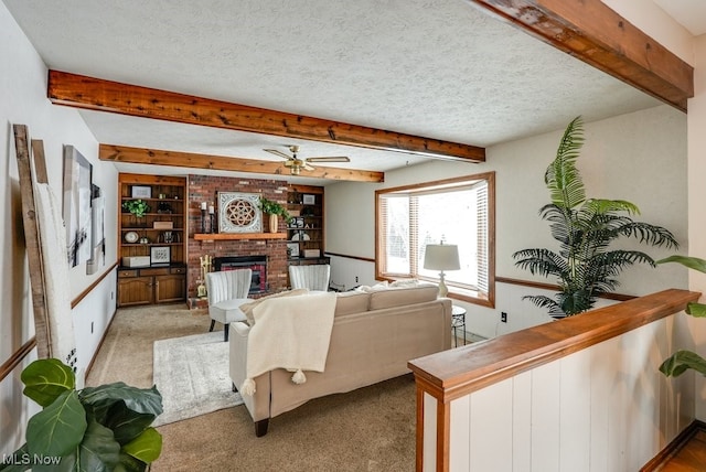 living area featuring light carpet, ceiling fan, beamed ceiling, a textured ceiling, and a brick fireplace