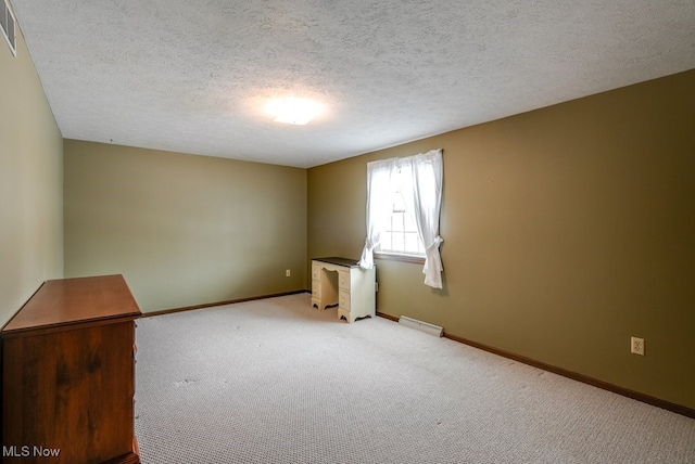 unfurnished room featuring visible vents, baseboards, a textured ceiling, and light colored carpet